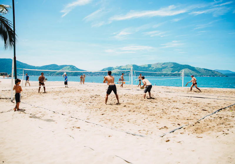 Beach volley club players warming up together by the nets.